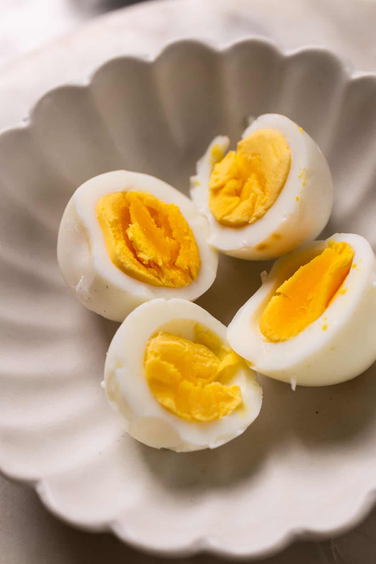 half cut hard boiled air fryer eggs in a white bowl