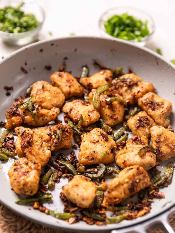 Air Fryer salt and pepper chicken in a frying pan ready to be served
