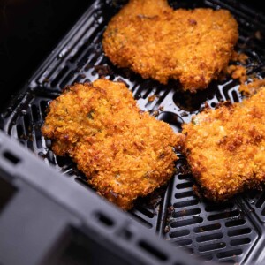 fried chicken cooking in an air fryer basket
