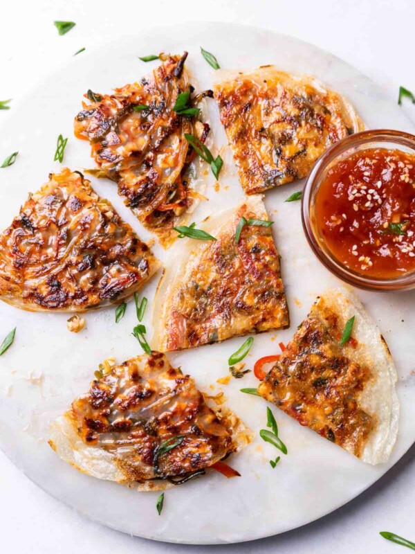 rice paper pancakes served on a round white platter with a dipping sauce