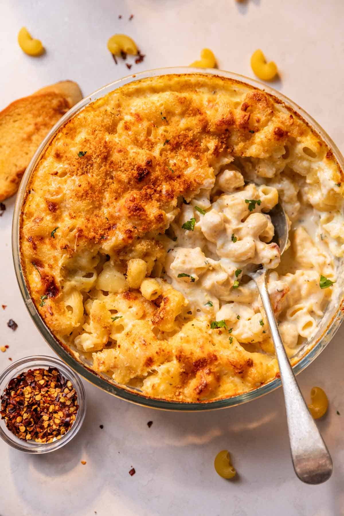 crinkly top of air fryer mac and cheese broken into to reveal it's creamy interior