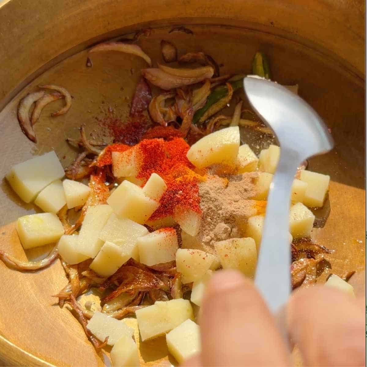 dahi tadka recipe - step 5 - add potatoes + spices and cook