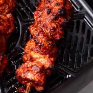 An image of freshly cooked air fryer chicken tikka still in the air fryer basket