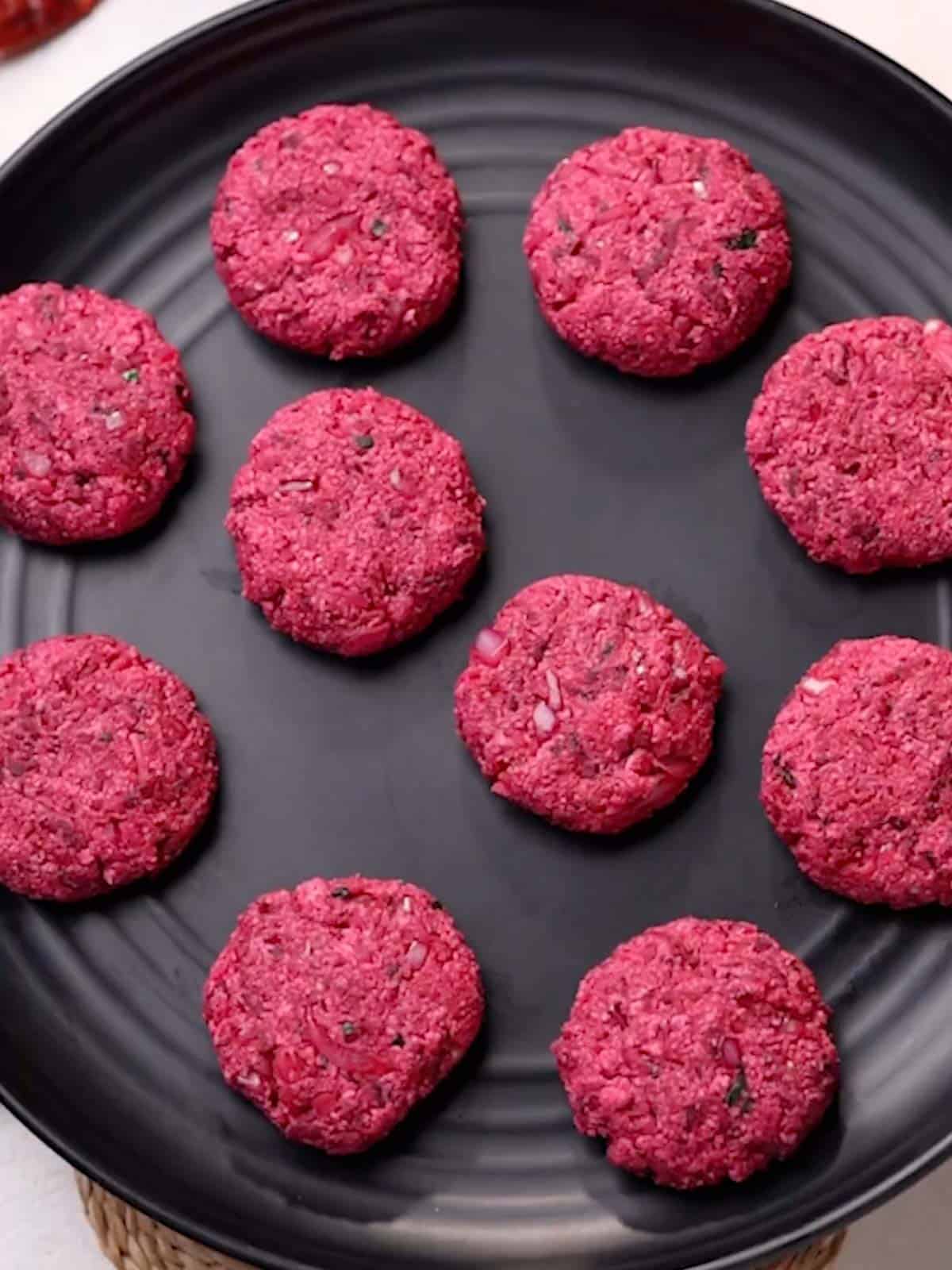 beetroot tikkis placed on a round black platter