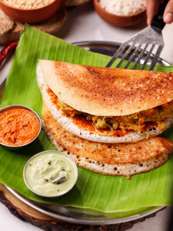 Serving mysore masala dosa with two chutneys on a banana leaf