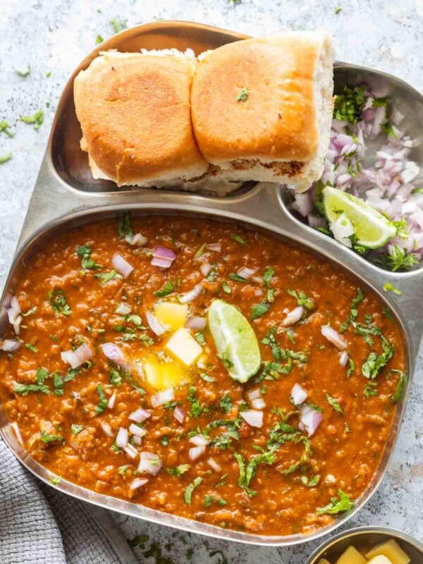 pressure cooker pav bhaji served on a sectioned plate with accompaniments