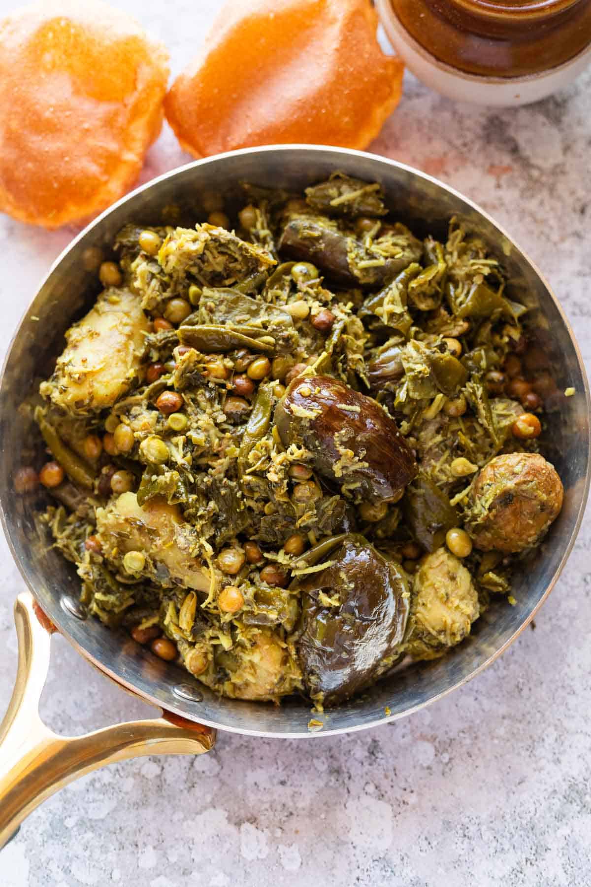 an image of shortcut undhiyu still in a pan with accompaniments