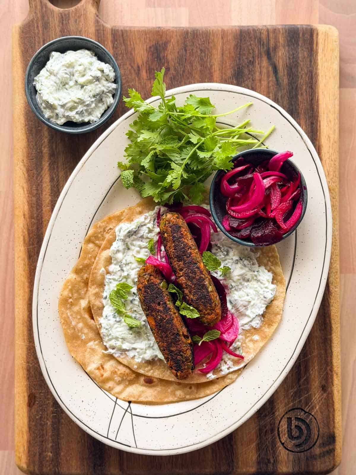an image of veg seekh kebabs served on a roti with accompaniments