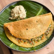 Stuffed Moong Dal Chilla served with chutney on the side on a banana leaf plate