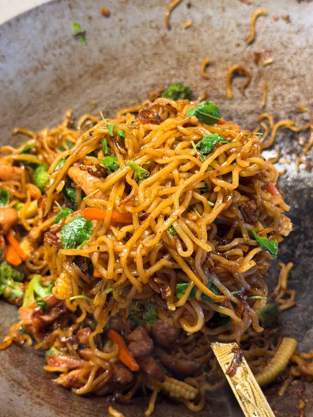close up image of Thai drunken noodles in the wok it was cooked in